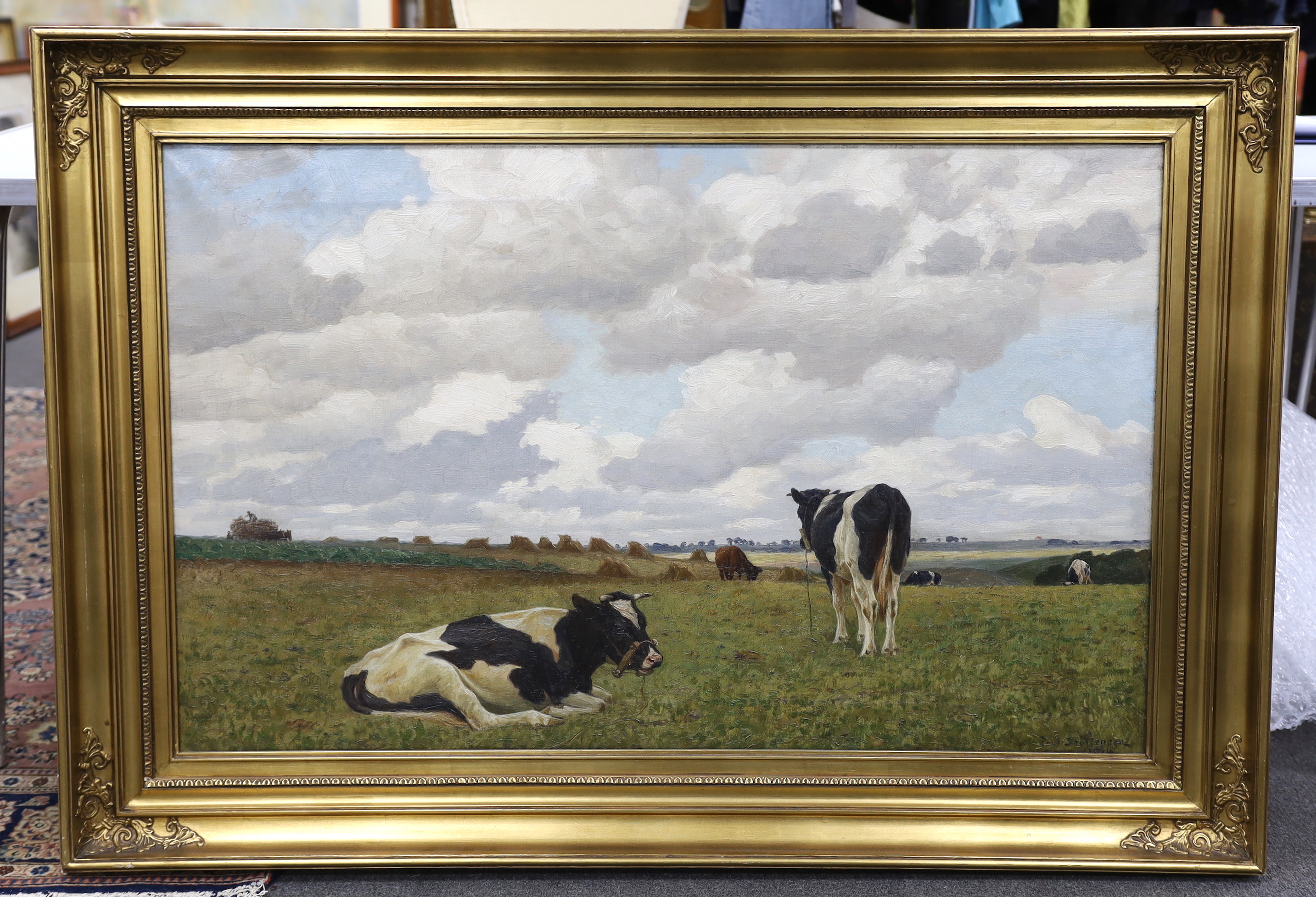 Poul Steffensen (1866-1923), oil on canvas, Cattle grazing before hayricks, signed and indistinctly dated, 63 x 102cm